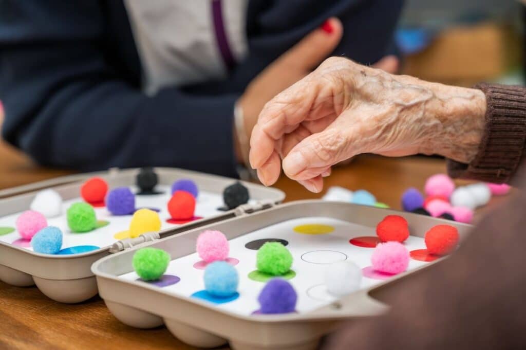 Senior hand using a Montessori Method resource for cognitive enhancement