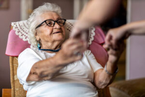 Older woman holding hands with her caregiver
